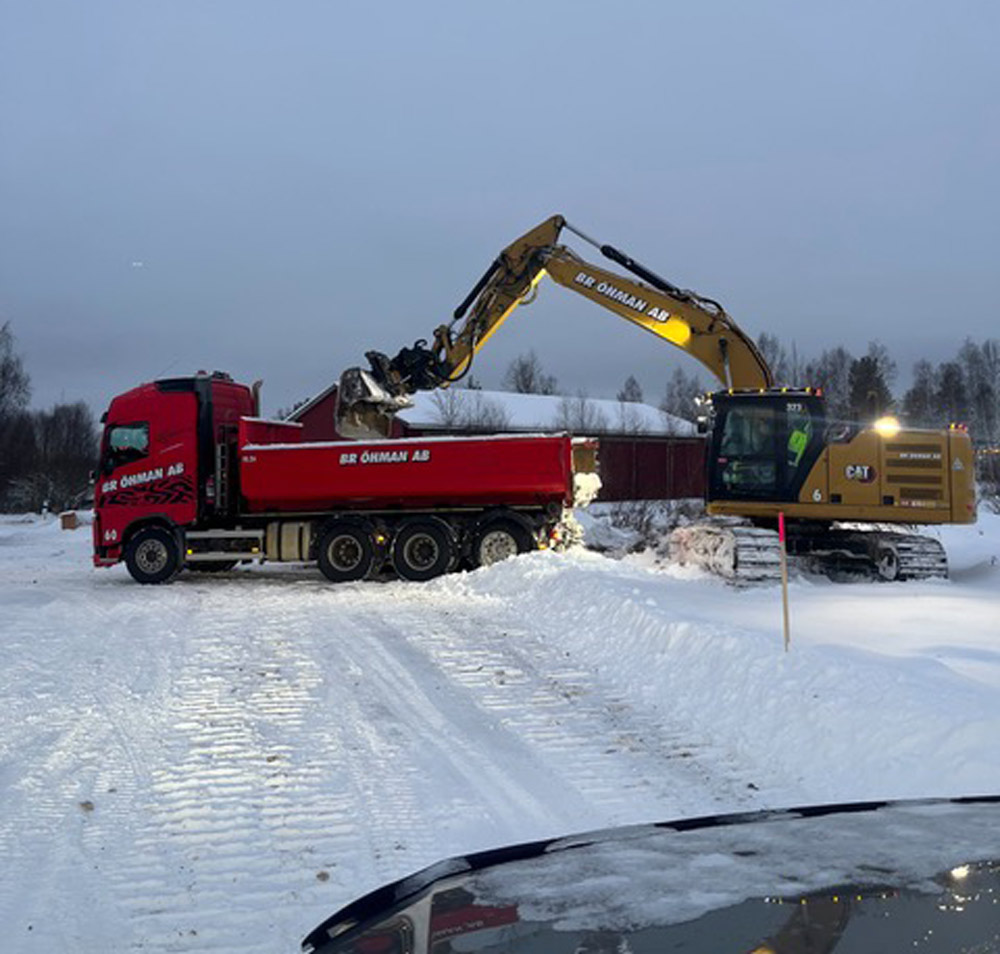 En grävskopa lastar i ett släp