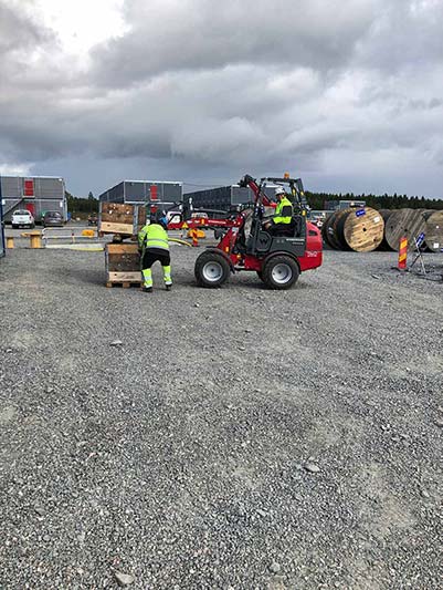 Röd traktor på grus.