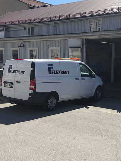 Flexrent van driving in to a garage.